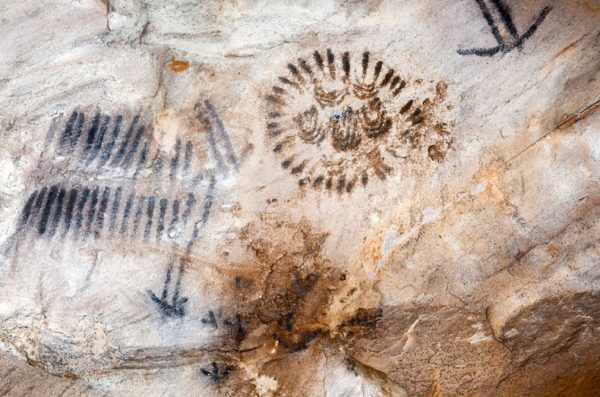 placestoseeaboriginalart Aboriginal rock art with ancient symbols painted on a cave wall.
