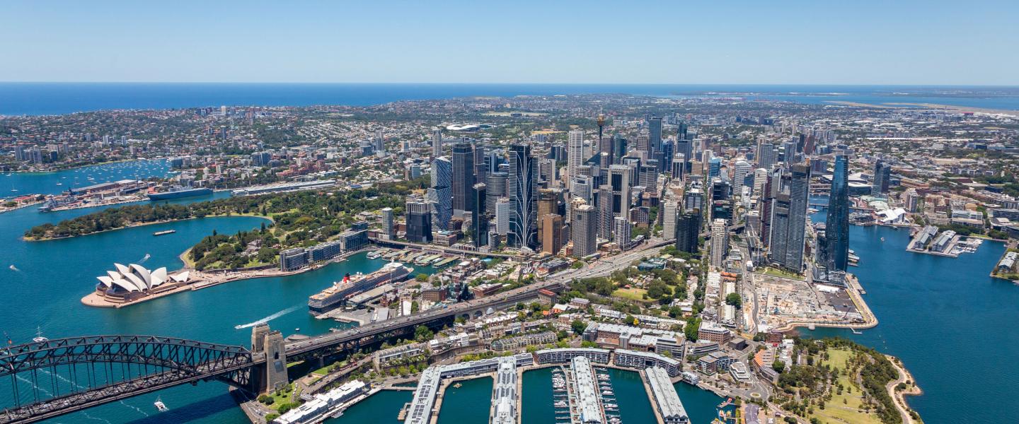 An aerial view of Sydney Harbour with the Opera House and Harbour Bridge.